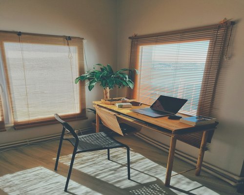 A well-balanced workspace near a window introducing filtered soft daylight for comfortable reading